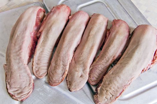 Photo of raw pork tongue on grey background