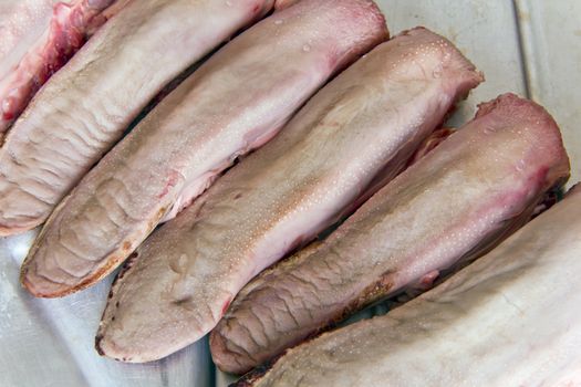 Photo of raw pork tongue on grey background