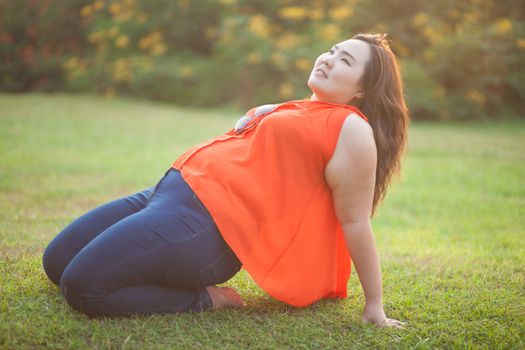 Happy fatty asian woman posing outdoor in a park