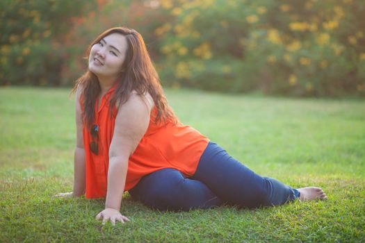 Happy fatty asian woman posing outdoor in a park