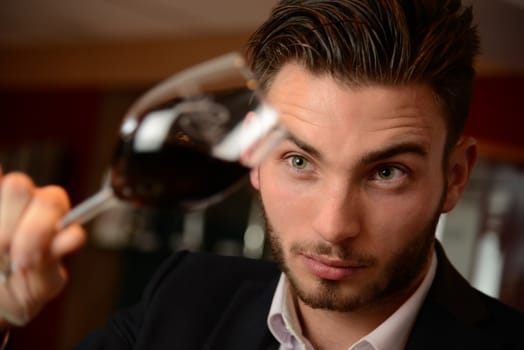 Young man with redwine glasses at celebration or party