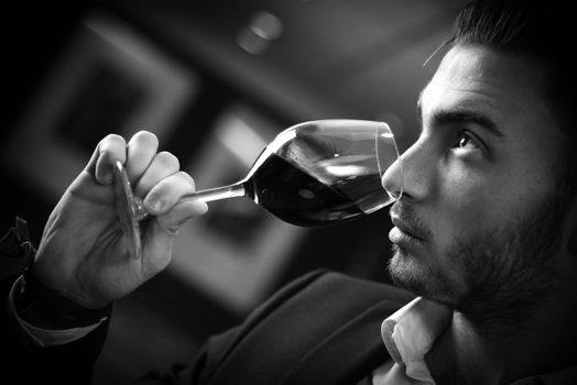 Young man with redwine glasses at celebration or party