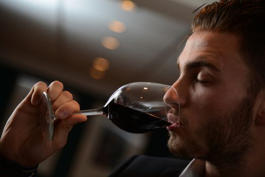 Young man with redwine glasses at celebration or party