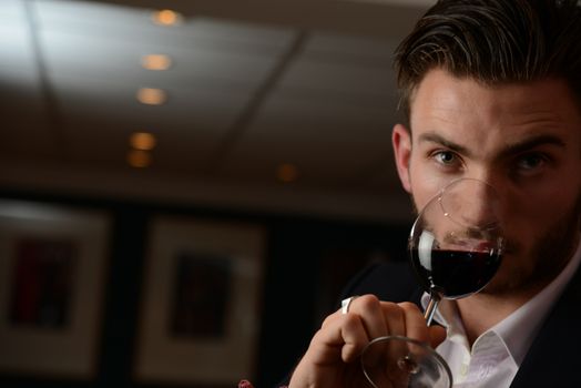 Young man with redwine glasses at celebration or party