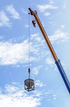 Crane hoist concrete bucket at construction site