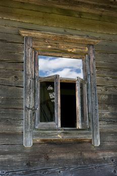 Old window on a wooden farm house wall