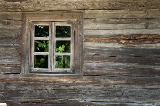 Old window on a wooden farm house wall