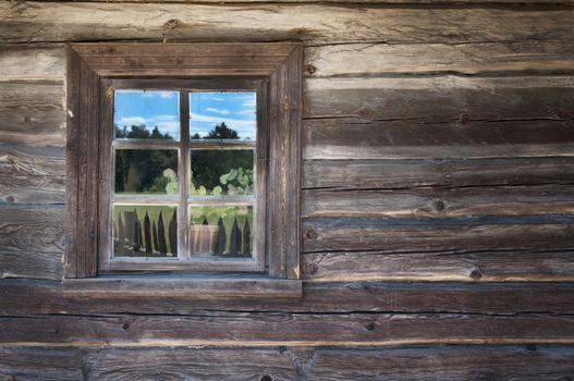 Old window on a wooden farm house wall