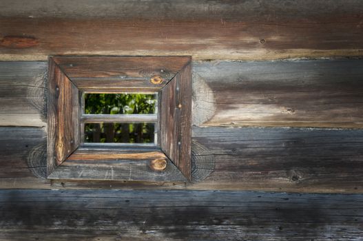 Old window on a wooden farm house wall