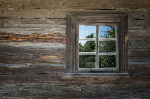 Old window on a wooden farm house wall