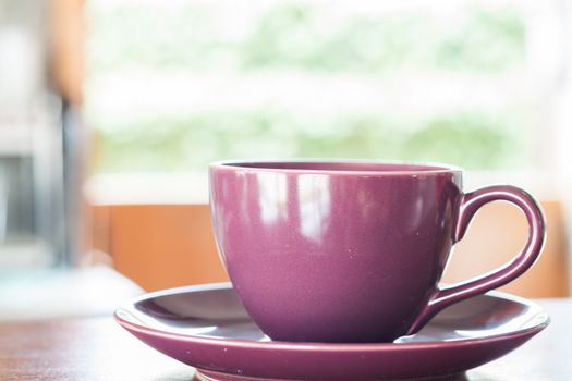 Purple coffee cup on wooden table, stock photo