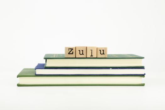 zulu word on wood stamps stack on books, language and study concept