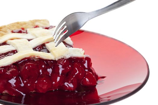 A serving of cherry pie about to be cut into with a fork.  Shot on white background.
