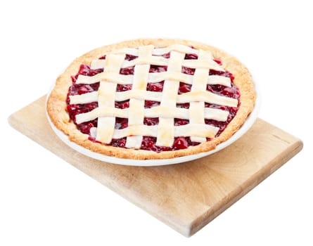 Delicious homemade cherry pie cooling on a wooden cutting board. Shot on white background.