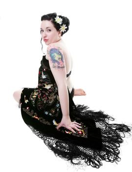 Beautiful rockabilly girl draped in a gorgeously embroidered black velvet shawl.  Shot on white background.