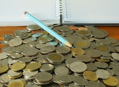 The amount of money placed on the table. A notebook and pencil to note the increase of money.                              