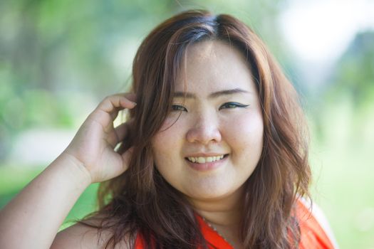 Close up of happy fatty asian woman outdoor in a park