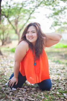 Happy fatty asian woman posing outdoor in a park