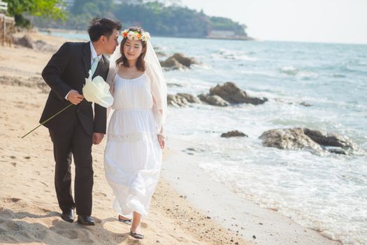 Happy young asian couple in love outdoor on the beach