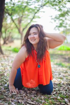 Happy fatty asian woman posing outdoor in a park