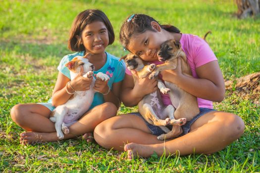 little asian girls and puppy in the garden