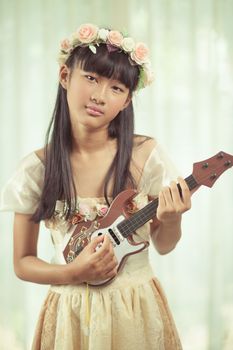 Portrait of a beautiful asian girl play guitar