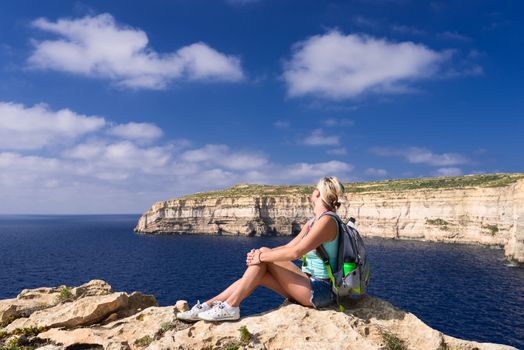 Girl looking on coast line near Azure Window on Gozo Island, Malta