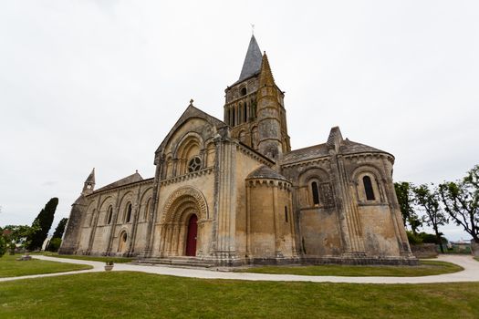 Side, abse and tower views of Aulnay de Saintonge church in Charente Maritime region of France