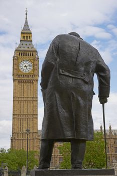 Statue of Winston Churchill in Parliament Square in London, England with the Elizabeth Tower of the Houses of Parliament in the background
