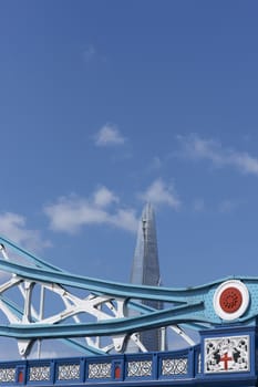 Steel and glass structure of the Shard towering above the historic structure of Tower Bridge in London, United Kingdom