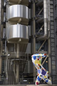 Mascot for the 2012 London Olympic games with the modern architecture of the Lloyds of London building in the background.