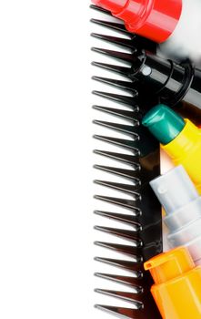 Frame of Colorful Various Hair Styling Products on Black Comb isolated on white background