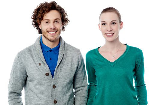 Trendy young smiling couple posing over white