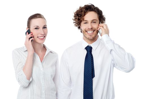 Smiling young corporates communicating over cell phone