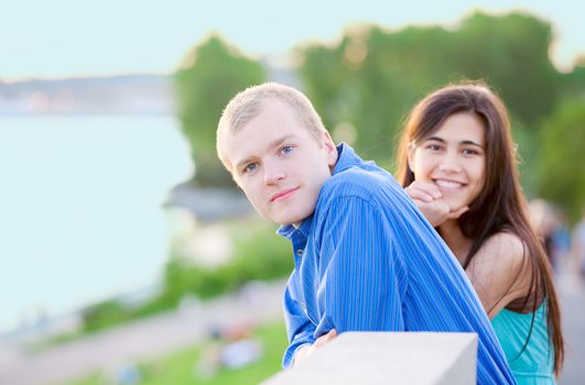 Happy interracial couple standing together outdoors by lake