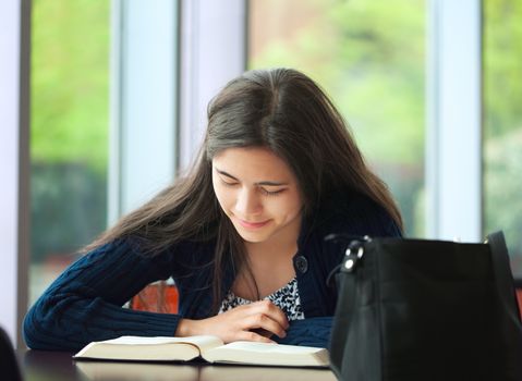 College student studying at school, reading book