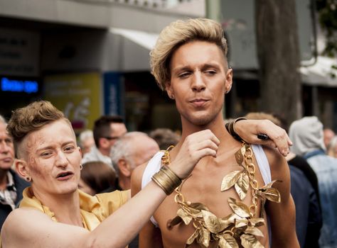 BERLIN, GERMANY - JUNE 21, 2014:Christopher Street Day.Crowd of people participate in the parade celebrates gays, lesbians, bisexuals and transgenders.Prominent in the image a two elaborately dressed gays.