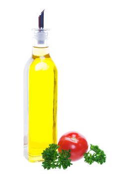 A bottle of olive oil with a young tomato and parsley.  Shot on white background.