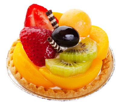 An Asian fruit tart stacked high with kiwi, peach, strawberries, melon balls, and a grape. Delicate rolls of striped white and dark chocolate garnish the center like mock chopsticks.  Shot on white background.
