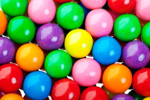 A colorful background of candy coated gumballs.