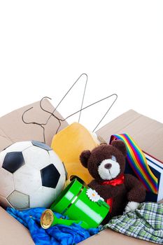 A box of unwanted stuff ready for a garage sale or to donate to a charitable organization.  Generic teddy bear.  Shot on white background.