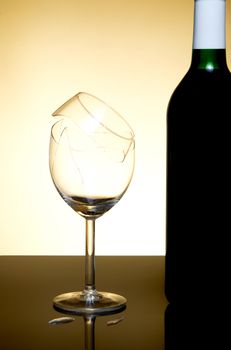 Vine bottle and broken glass on orange background