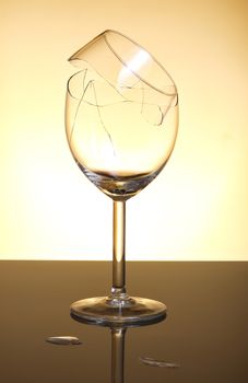 Broken vine glass on orange background