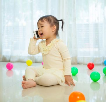 Portrait of pretty asian little girl talking on mobile phone