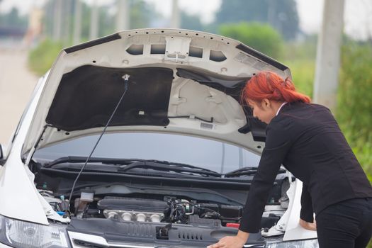 Young beautiful business asian woman with car broke down