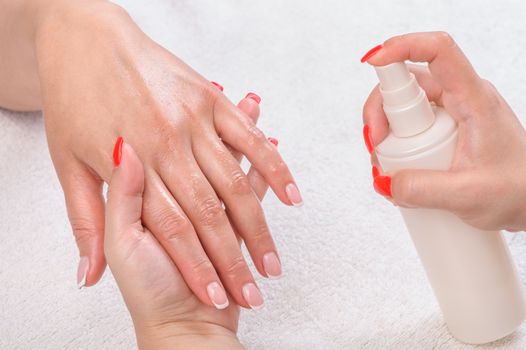 beauty salon, manicure applying, moisturising with thermal water