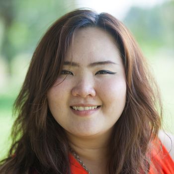 Close up of happy fatty asian woman outdoor in a park