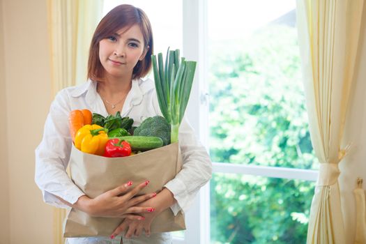 Happy Young Asian Woman with vegetables in shopping bag