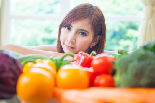 Happy asian woman cooking vegetables green salad in the kitchen