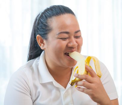 Fat asian woman with banana on white
